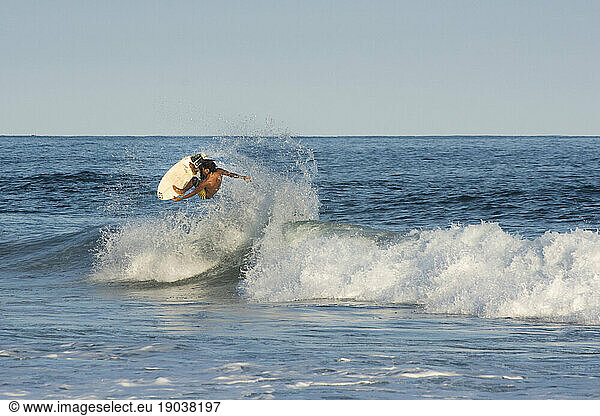 Male surfer catches some air in Agua Blanca  Oaxaca  Mexico.