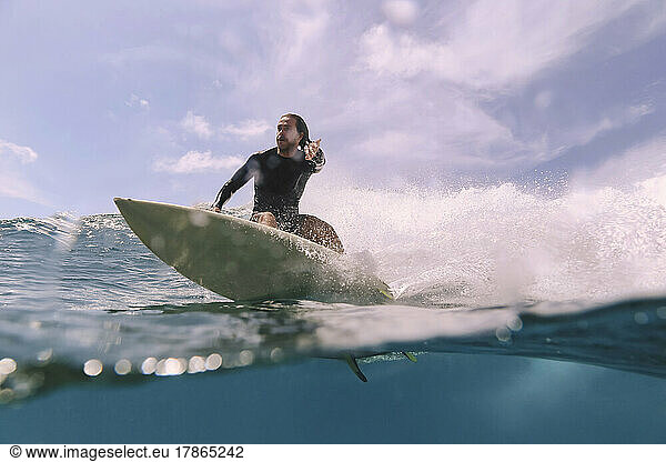 Male surfer on a wave at sunny day