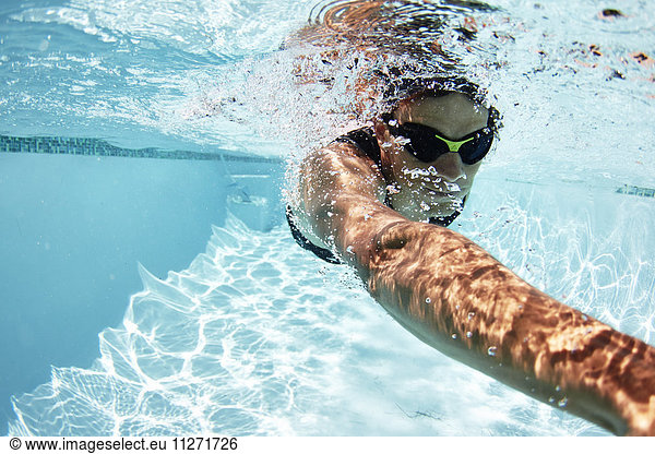 Male swimmer athlete swimming underwater in swimming pool