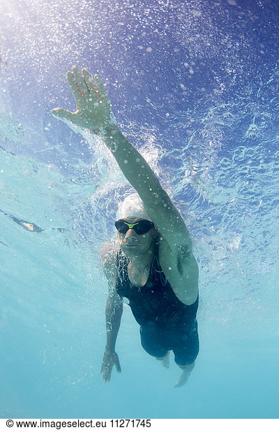 Male swimmer athlete swimming underwater in swimming pool