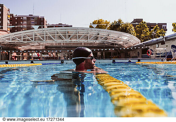 Male swimmer by lane marker in swimming pool