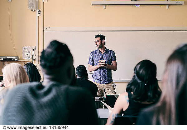 Male teacher teaching multi-ethnic students in classroom