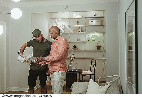 Male technician and mature man discussing over document at home