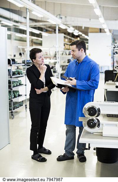 Male technician communicating with client in factory