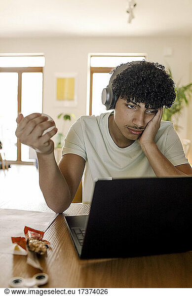 Male teenager using laptop while sitting at home