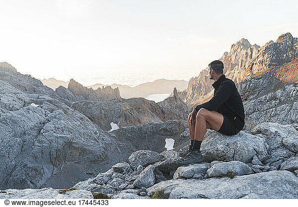 Male tourist looking at Picos de Europe mountain ranges at sunrise  Cantabria  Spain
