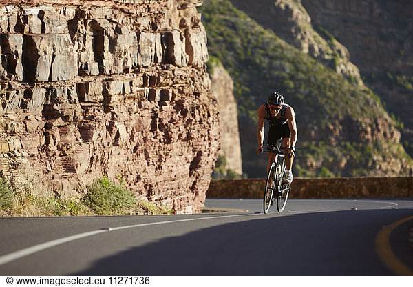 Male triathlete cycling uphill