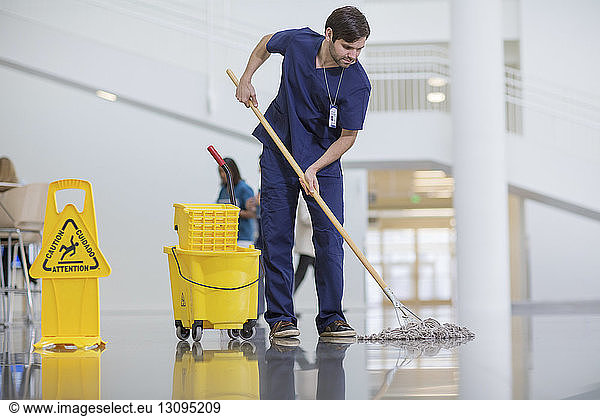 Male worker cleaning hospital floor