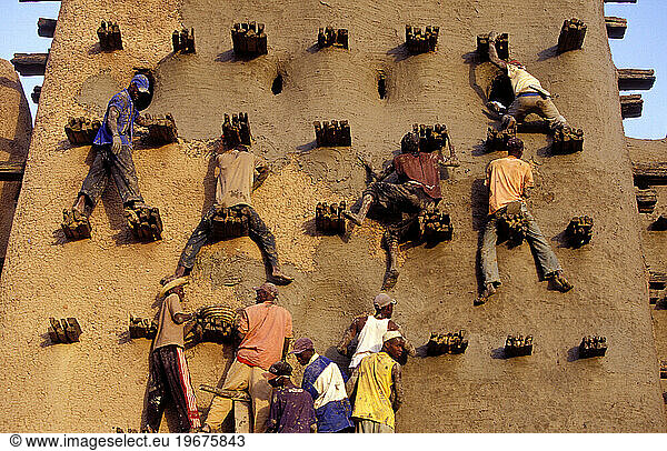 Mali Djenne People working on restoring and applying the Grand Mosque with fresh mud