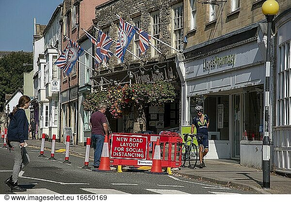 Malmesbury  Wiltshire  England  UK  Sozialer Abstand Verkehrskegel und Beschilderung in der Hauptstraße dieser historischen Marktstadt  Radfahrer und Fahrrad...