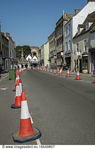 Malmesbury  Wiltshire  England  Vereinigtes Königreich  Verkehrsleitkegel und Beschilderung in der Hauptstraße dieser historischen Marktstadt  Blick auf das Marktkreuz.