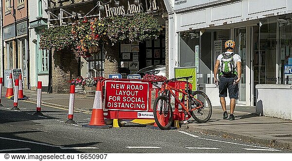 Malmesbury  Wiltshire  England  Vereinigtes Königreich  Verkehrsleitkegel und Beschilderung in der Hauptstraße dieser historischen Marktstadt  Radfahrer und Fahrrad.