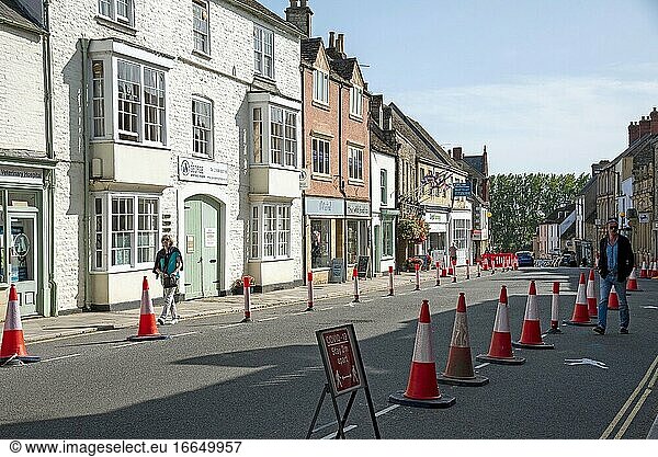 Malmesbury  Wiltshire  England  Vereinigtes Königreich  Verkehrsleitkegel und Schilder zur sozialen Abgrenzung in der Hauptstraße dieser historischen Marktstadt.