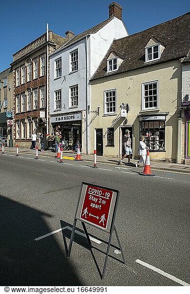 Malmesbury  Wiltshire  England  Vereinigtes Königreich  Verkehrsleitkegel und Schilder zur sozialen Abgrenzung in der Hauptstraße dieser historischen Marktstadt.
