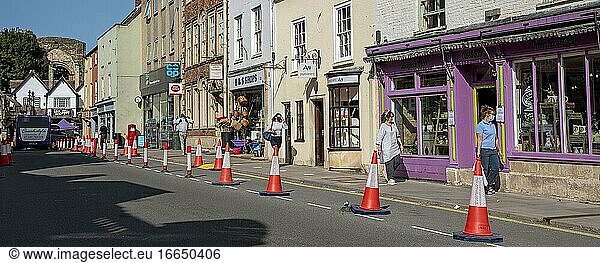 Malmesbury  Wiltshire  England  Vereinigtes Königreich  Verkehrsleitkegel und Schilder zur sozialen Abgrenzung in der Hauptstraße dieser historischen Marktstadt.