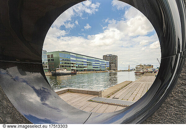 Malmo University by canal against sky seen from sculpture