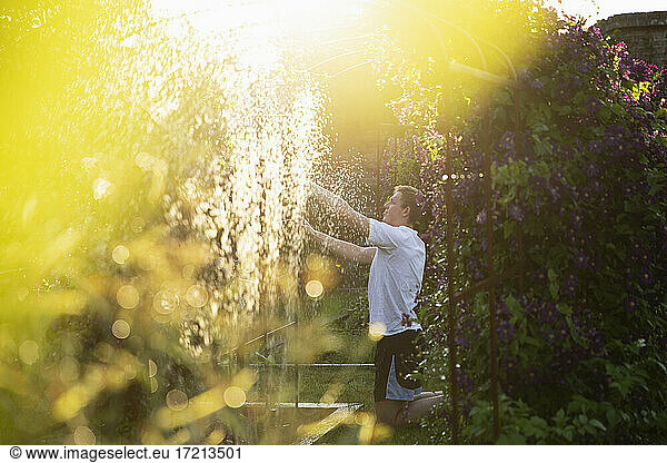 Man adjusting sprinkler in sunny summer garden