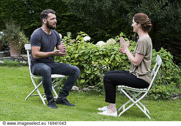 Man and a therapist seated in a garden  talking.