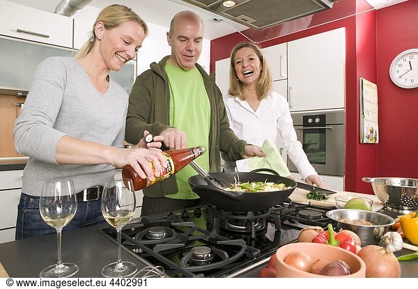 Man and two women cooking a stir-fry together