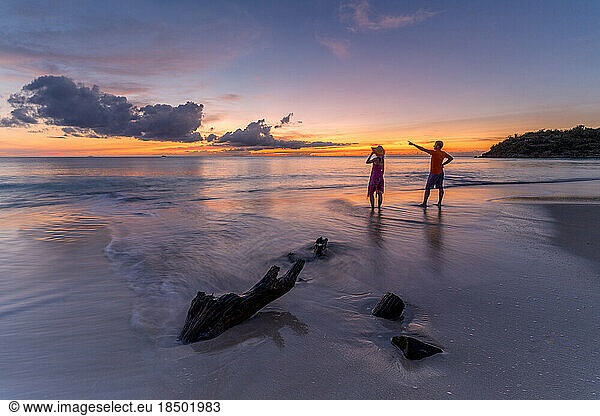 Man and woman admiring sunset on tropical beach  Caribbean