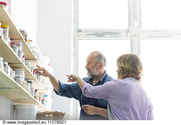 Man and woman browsing art supplies on shelves in art studio