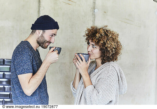 Man and woman drinking coffee and smiling at each other