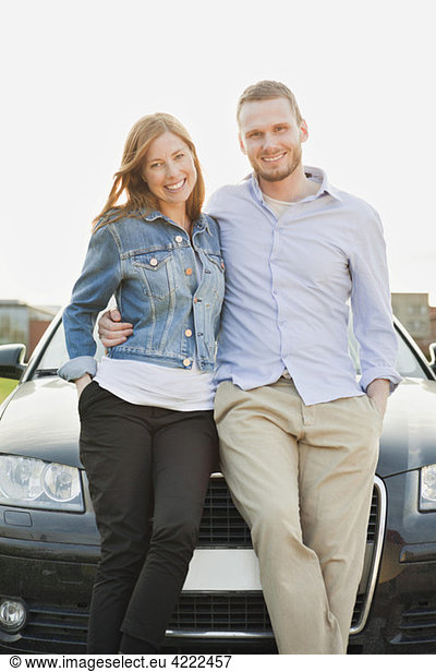 Man and woman in front of car