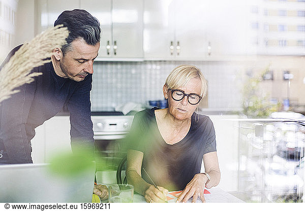 Man and woman in kitchen working at home