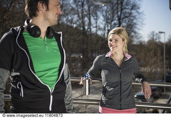 Man and woman in sportswear relaxing after workout