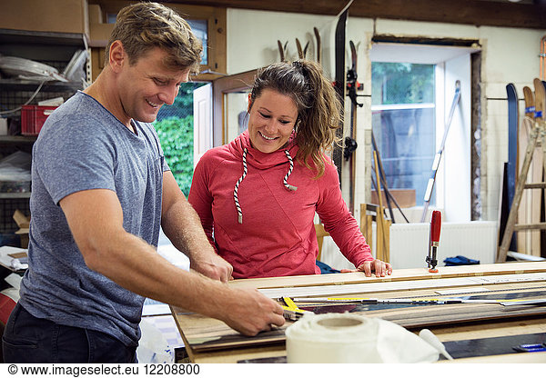 Man and woman in workshop  making ski equipment