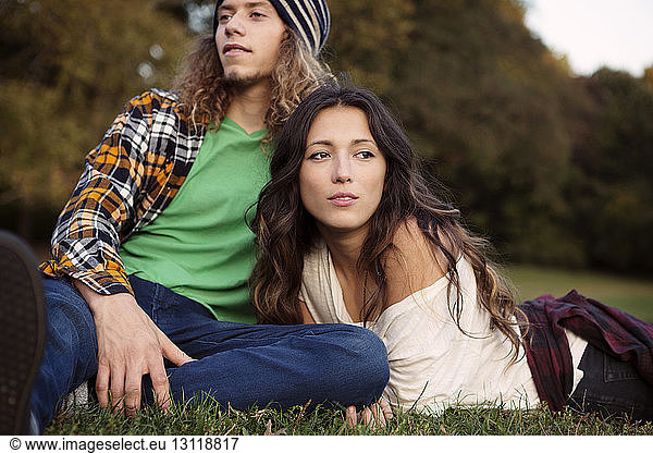 Man and woman relaxing on grassy field