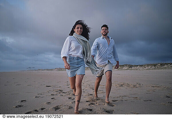 Man and woman running together at beach