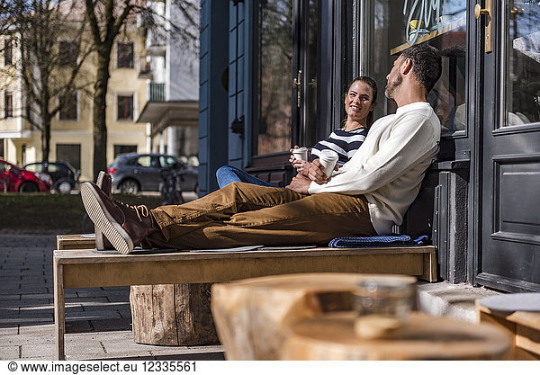 Man and woman sitting outside a cafe talking