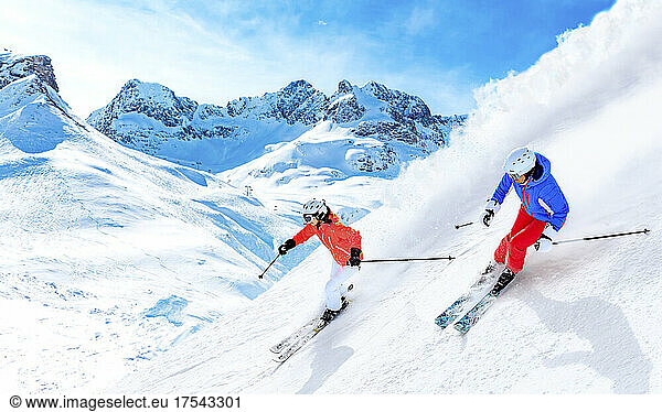Man and woman skiing downhill on snowcapped mountain in Lech  Austria