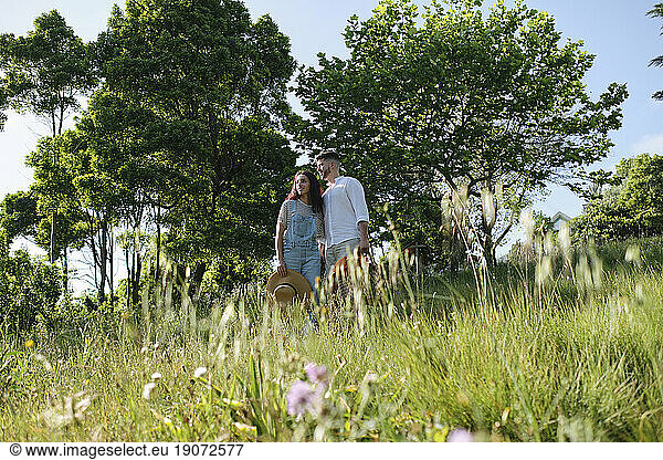 Man and woman standing on grass at sunny day