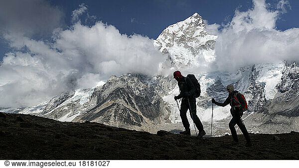 Man and woman trekking with Mt Everest  Nuptse and Kala Patthar in background  Himalayas  Solo Khumbu  Nepal