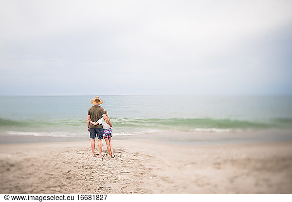 Man and Young Girl Standing Looking Out at the Ocean in Indialantic FL