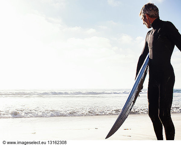 Man at coast with surfboard  Encinitas  California  USA