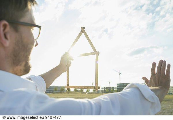 Man at development area holding model house