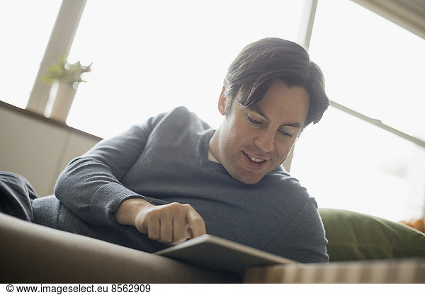 Man at home using electronic tablet