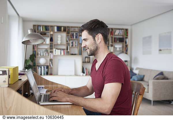 Man at home using laptop