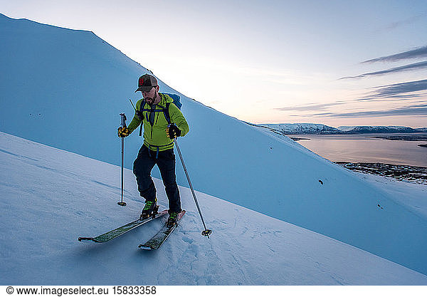 Man backcountry skiing in Iceland at Sunrise