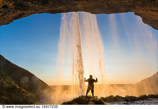 Man behind Seljalandsfoss Waterfall  South Iceland  Iceland