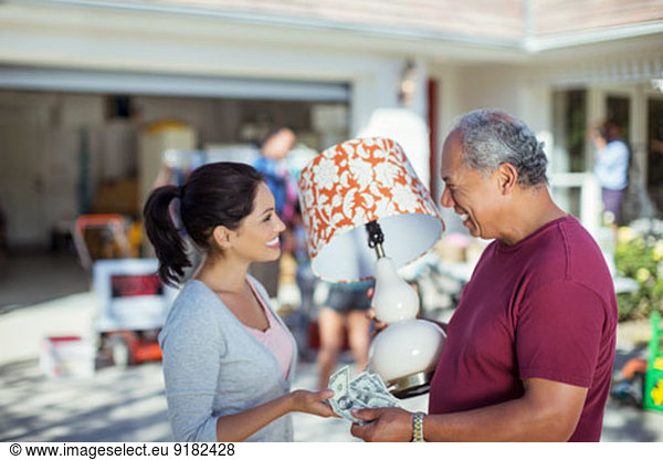Man buying lamp at yard sale