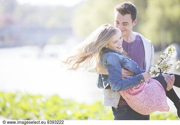 Man carrying girlfriend outdoors