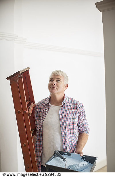 Man carrying ladder and paint tray