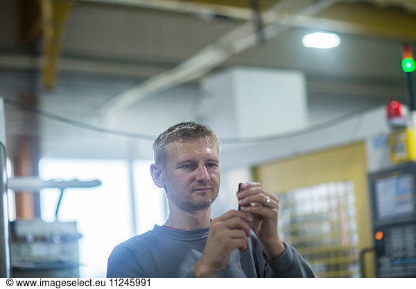 Man checking tool in grinding workshop