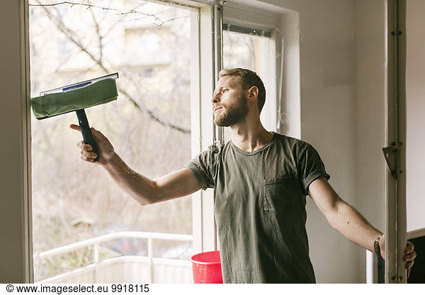 Man cleaning glass window