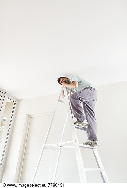 Man climbing ladder indoors