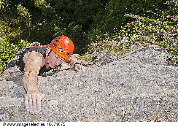 man climbing limestone cliff in South Wales